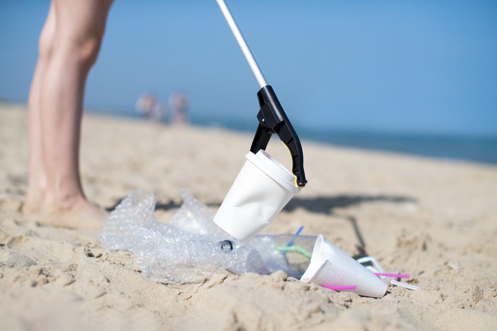 a person cleaning up litter on a beach