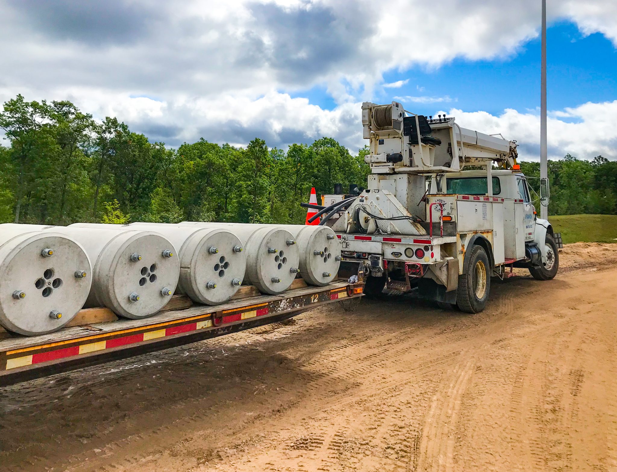 Truck transporting precast concrete pole bases
