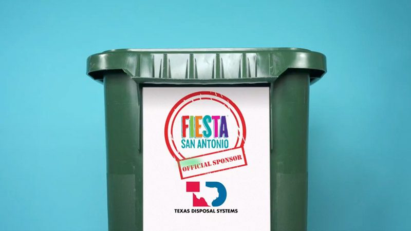 Standalone image of a Texas Disposal Systems bin with printed graphics that read "Fiesta San Antonio"