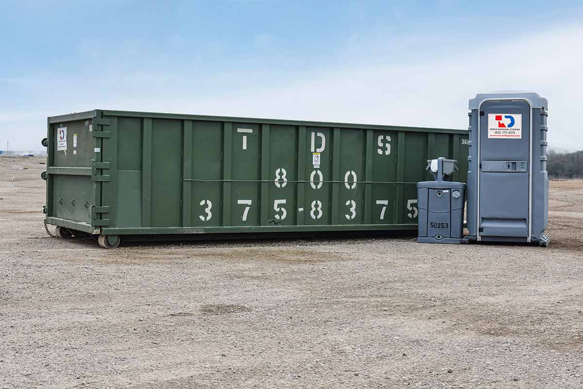 TDS roll off 30 yard dumpster next to portable restroom